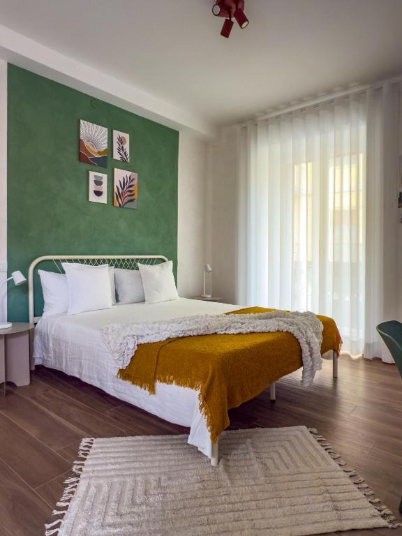 a bedroom with a large bed with a green wall at Arpi Uno in Foggia