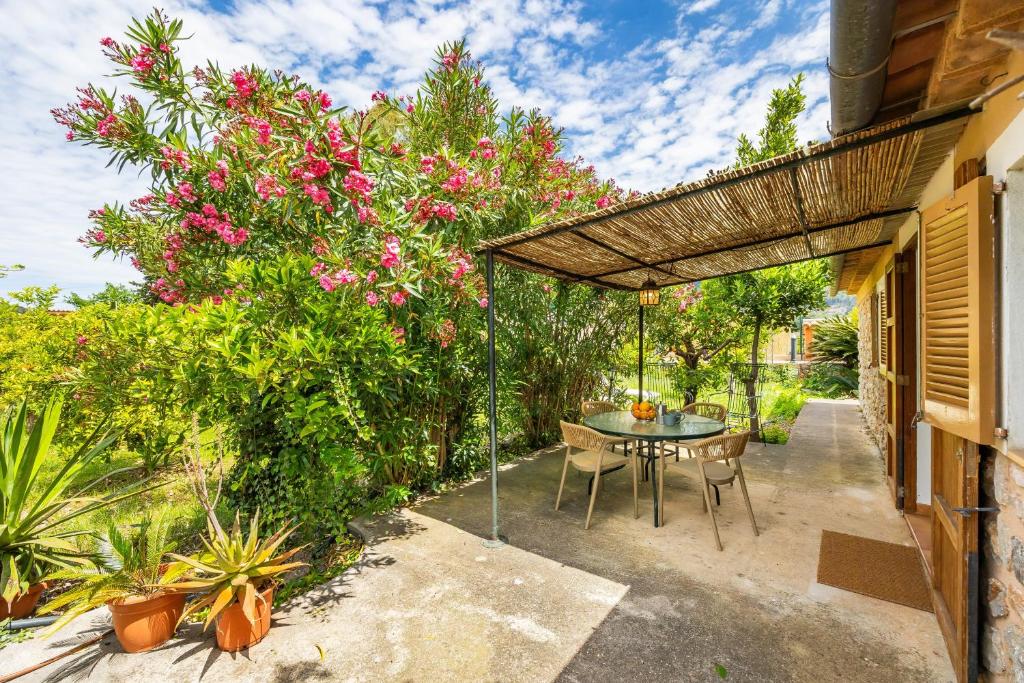 a patio with a table and chairs under an umbrella at Can Pep in Sóller