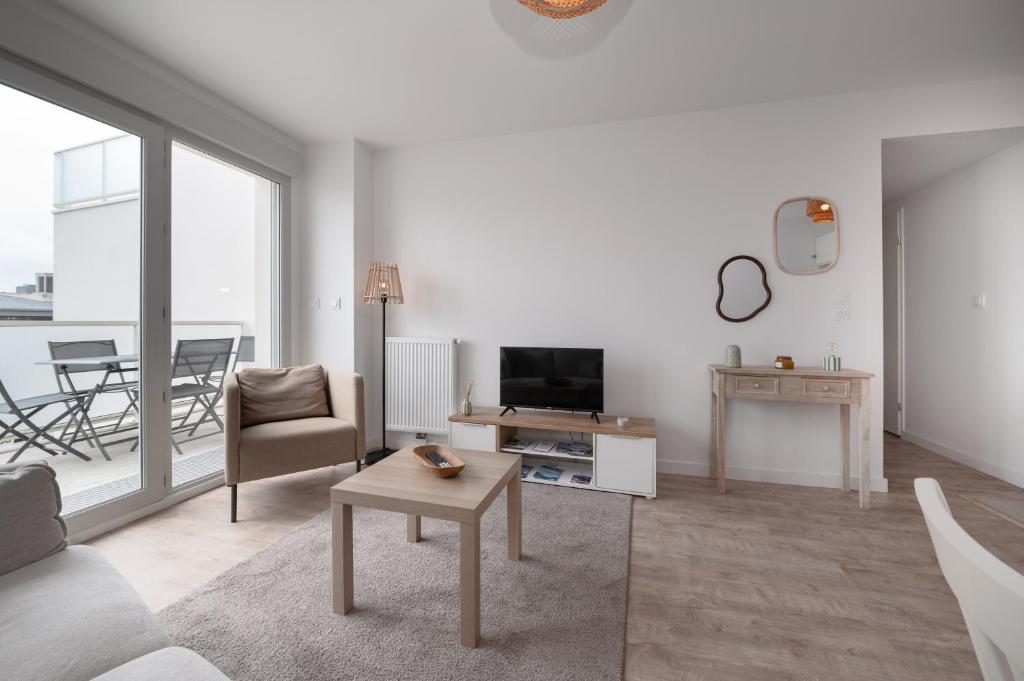 a living room with a couch and a tv at La belle étoile - 4 pers - balcon in Vannes