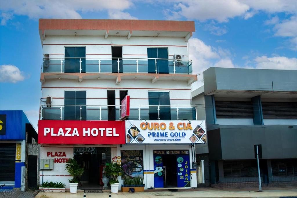 a white building with a hotel with a sign in front at Plaza Hotel in Itaituba