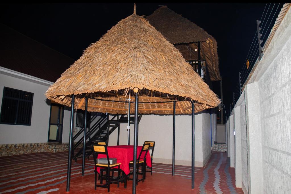 a room with chairs and a large thatch roof at Summit View Retreat in Moshi