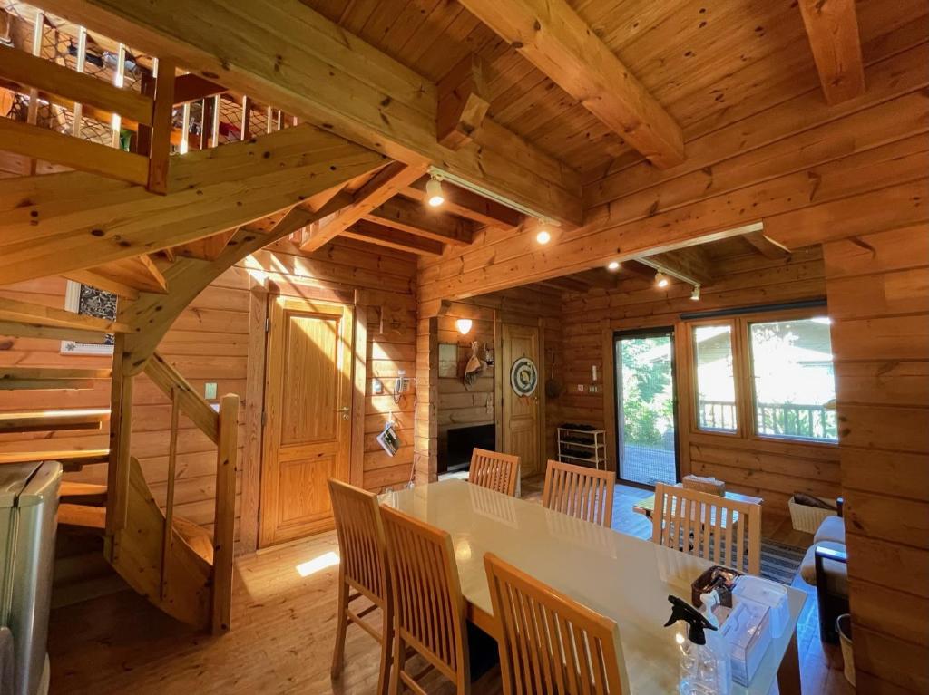 a log cabin dining room with a table and chairs at Sunny Side Cottage in Shimoda