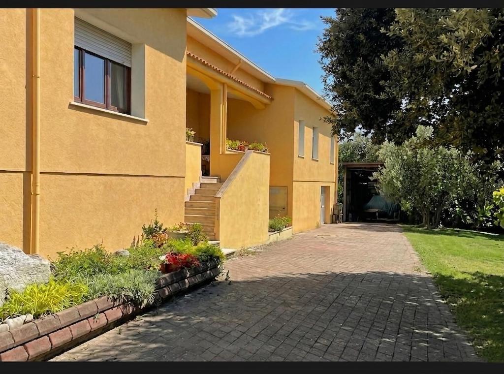 a house with a brick driveway next to a building at Prenda e Mare in Ottava Sassari