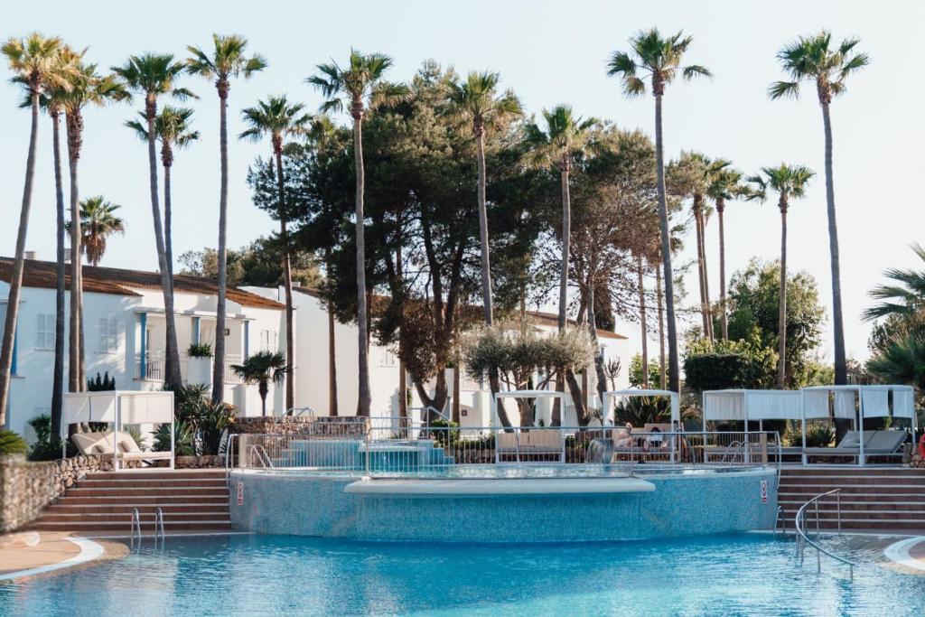 a pool at a resort with palm trees at Sagitario Princesa Playa in Son Xoriguer