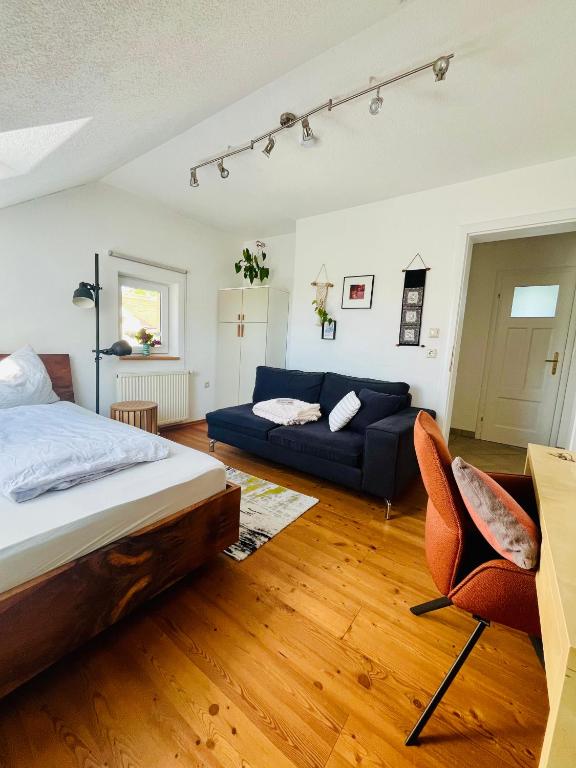 a bedroom with a bed and a couch at Gästezimmer Traisen in Traisen