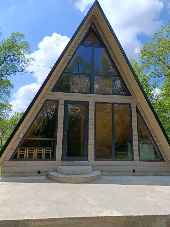 a house with a triangular roof with glass windows at A-frame family in Prokurava