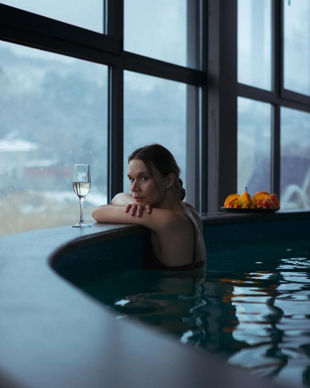 a woman sitting in a bath tub with a glass of wine at GetAp Resort Arzni in Arzni