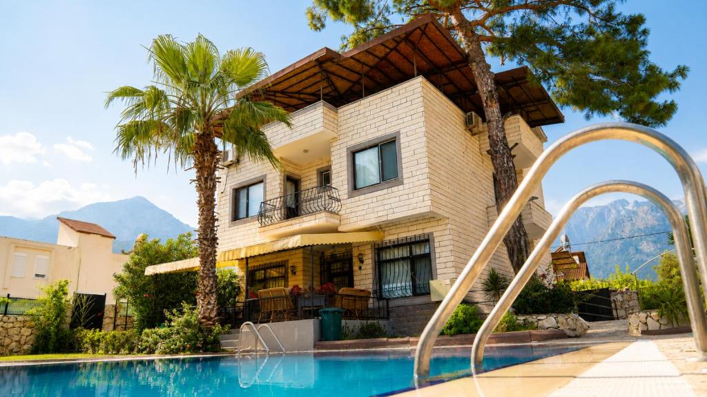 a house with a swimming pool in front of a house at Spacious Villa with Sea and Mountain View in Kemer