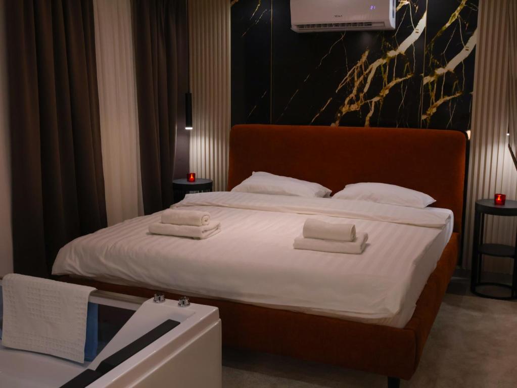 a bedroom with a large bed with white sheets at Rentalica in Belgrade