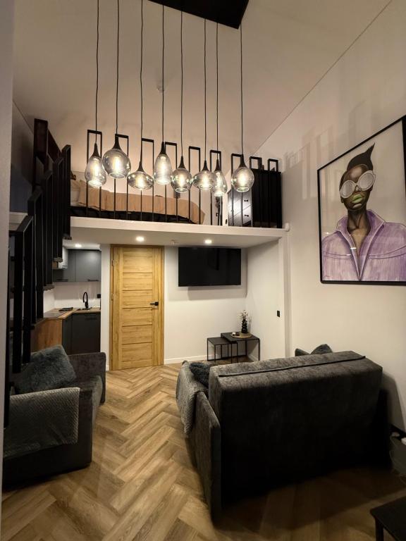 a living room with two couches and a chandelier at Grant City Loft in Kaunas