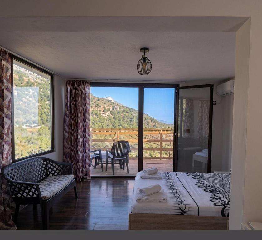 a bedroom with a bed and a balcony with a view at Vila zaho in Dhërmi