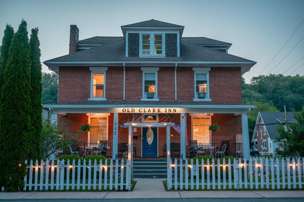 a red brick house with a gate in front of it at Old Clark Inn in Marlinton