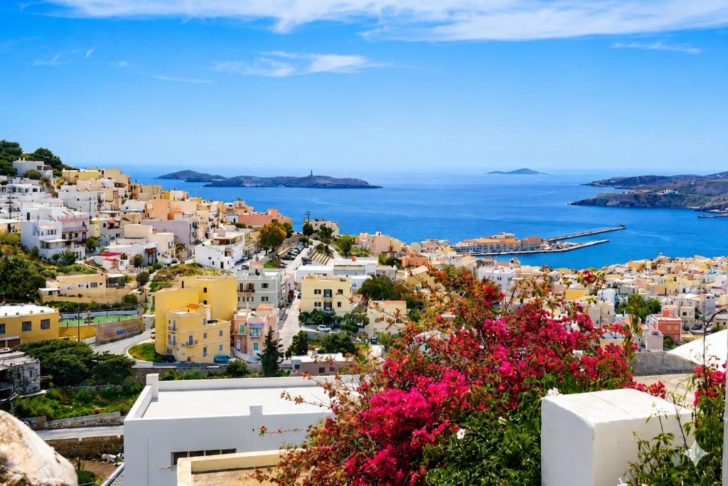 a view of the town of positano with pink flowers at Danielle 626 House Ano Syros in Ano Syros