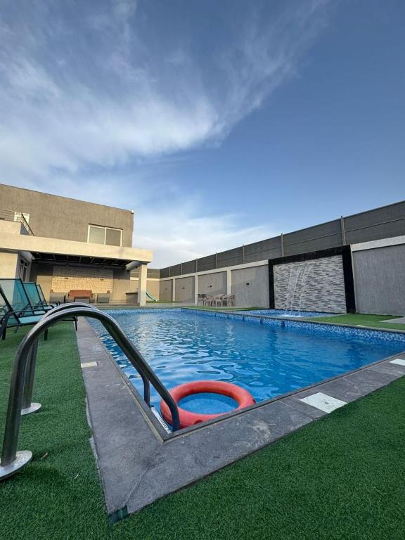 a swimming pool with a slide in front of a building at aqua chalets شاليهات أكوا in Al Rama