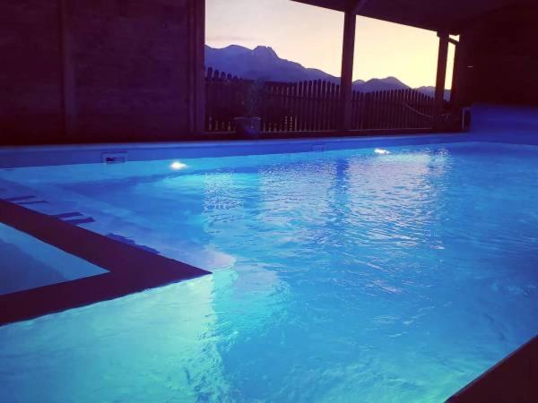 a large swimming pool with blue water in a building at ECO Willa Karpatia Ski&Wellness in Murzasichle