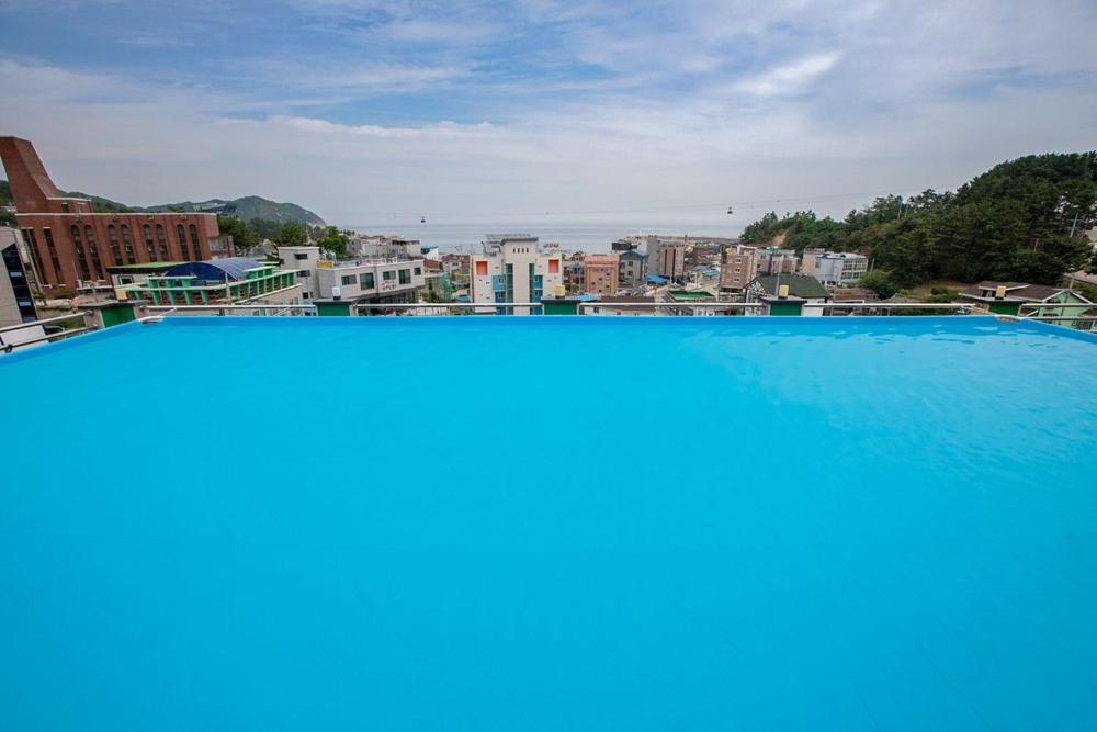 a large swimming pool with a view of a city at Pension Ora in Samcheok