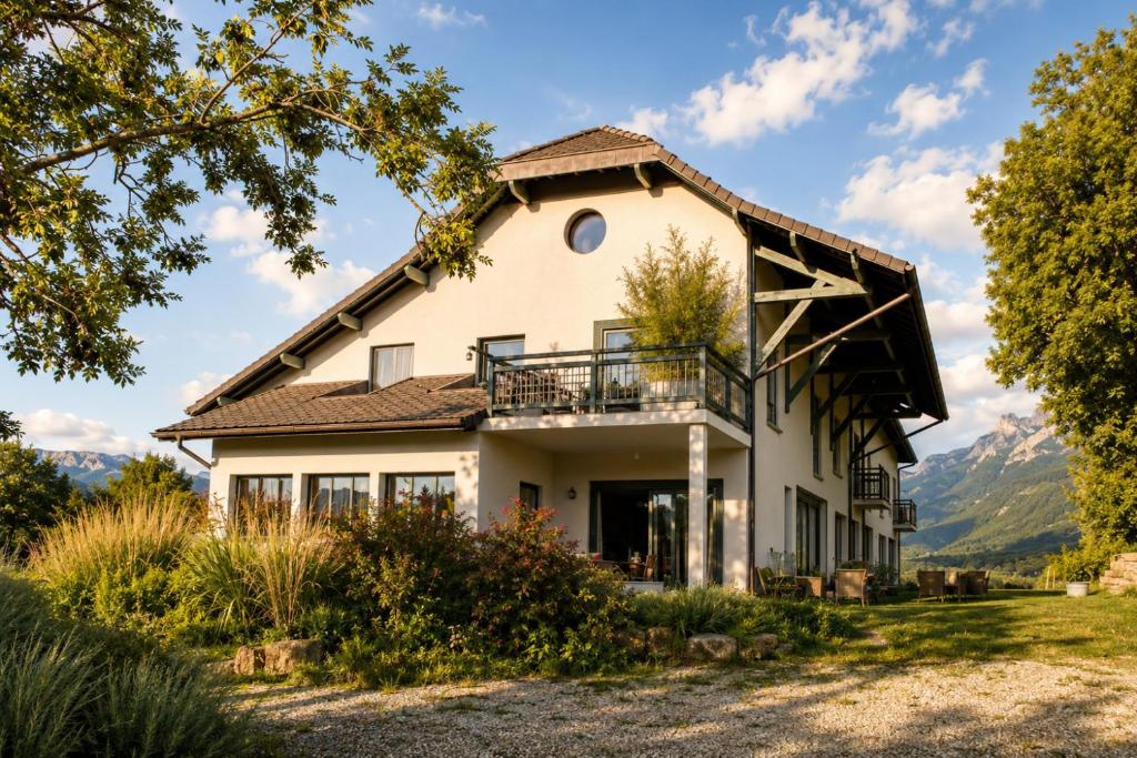 an exterior view of a house with mountains in the background at La Bergerie de Losse in Traize