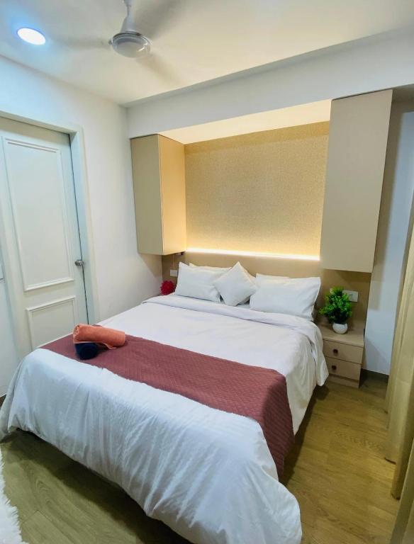 a bedroom with a large bed with white sheets at Neon AS Hotel in Pune