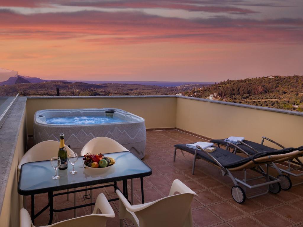 a balcony with a hot tub and a table and chairs at Villa Erontas -Private heated jacuzzi and mini pool in Makhairoí