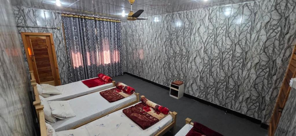 a room with two beds and a wall with patterns at Shangrella Hotel Malam Jabba in Malam Jabba