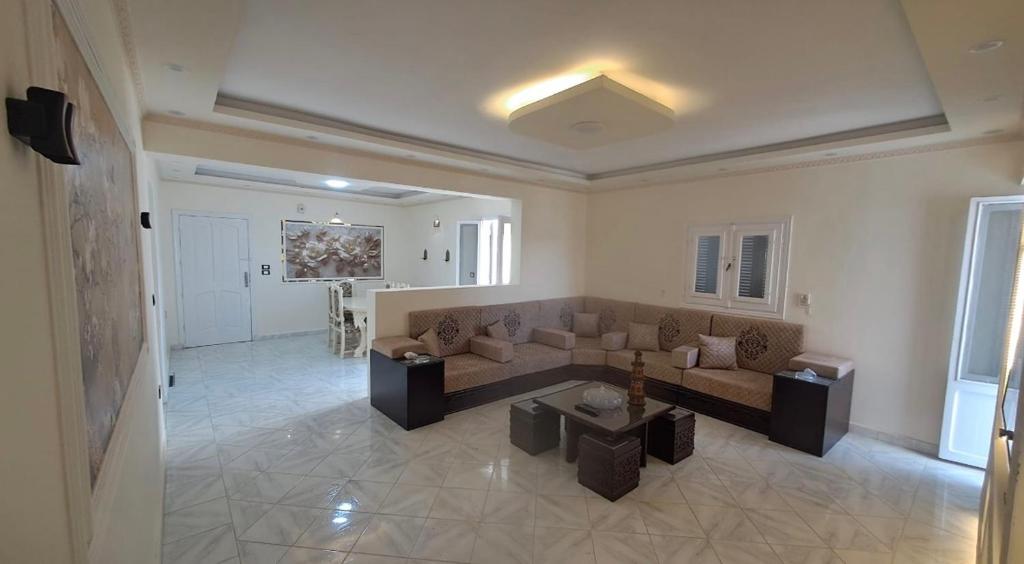 a living room with a couch and a table at Ruim apartement abo saeed in El Delr
