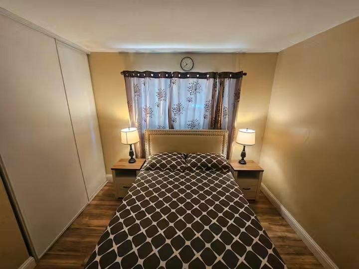 a bedroom with a bed and two lamps on two tables at Urban Retreat -Suite B in San Jose