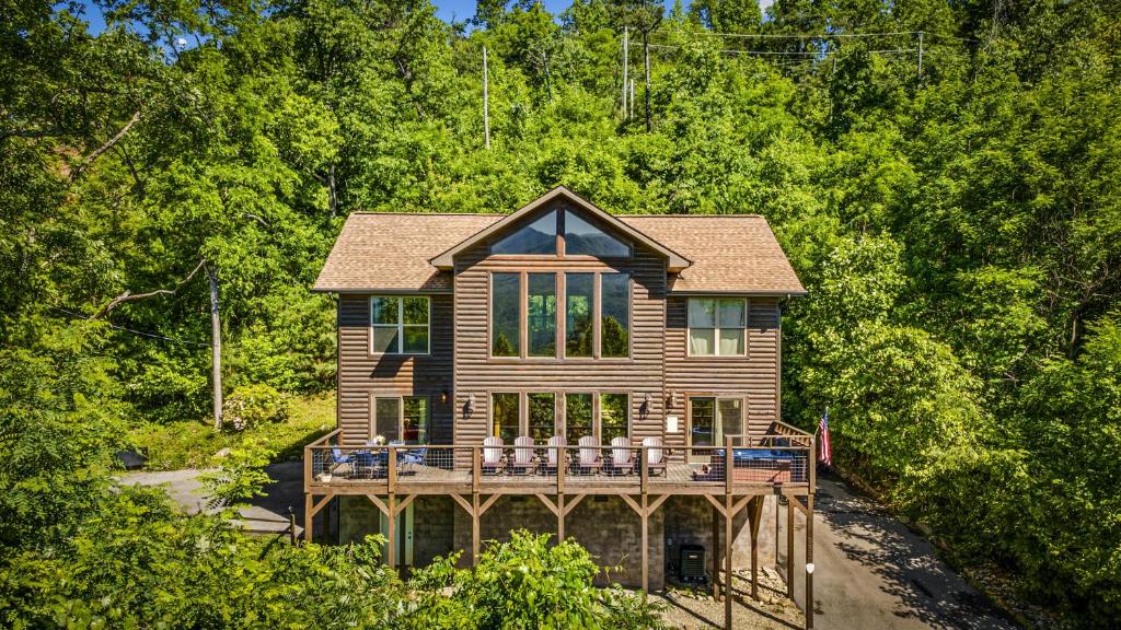 a wooden house with a deck in the woods at A Tree Top View home in Gatlinburg