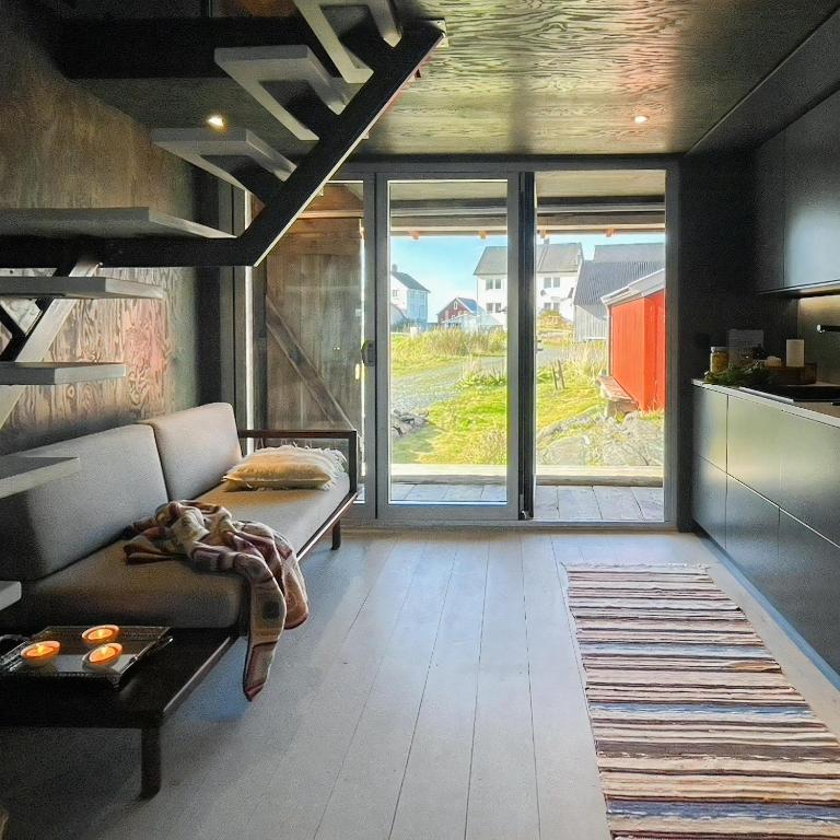 a living room with a couch and a large window at Seaside Boathouse In Veiholmen in Smøla