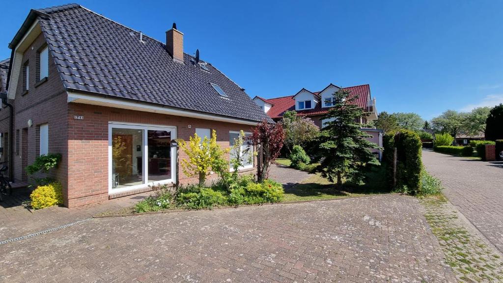 a brick house with a driveway in front of it at Ferienhaus Windland - mit Garten, Kamin und Sauna in Dranske