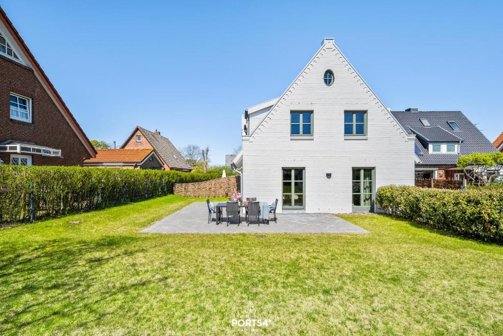 a white house with a table and chairs in the yard at Villa Tinnum Sylt in Tinnum