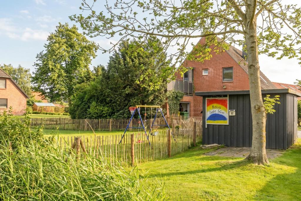 a house with a playground in a yard at Gode Sünn in Tating