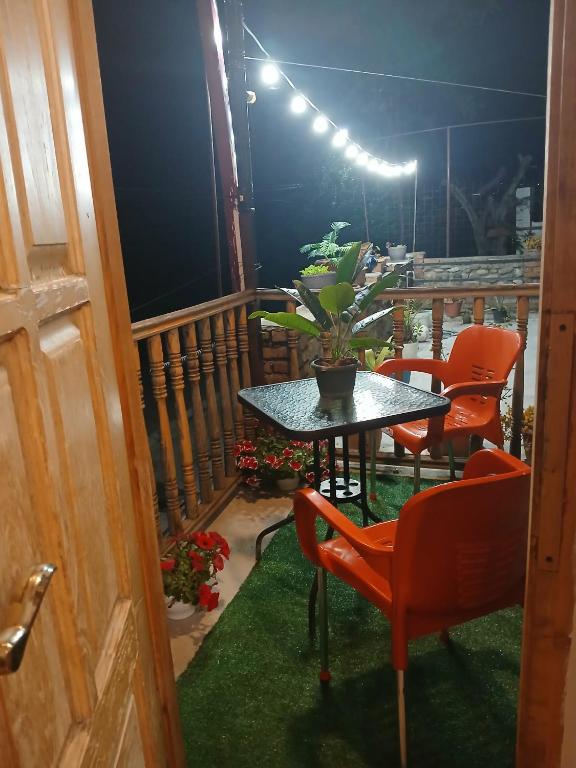 a table and chairs on a balcony with a plant at Guest house Babaka in Sighnaghi