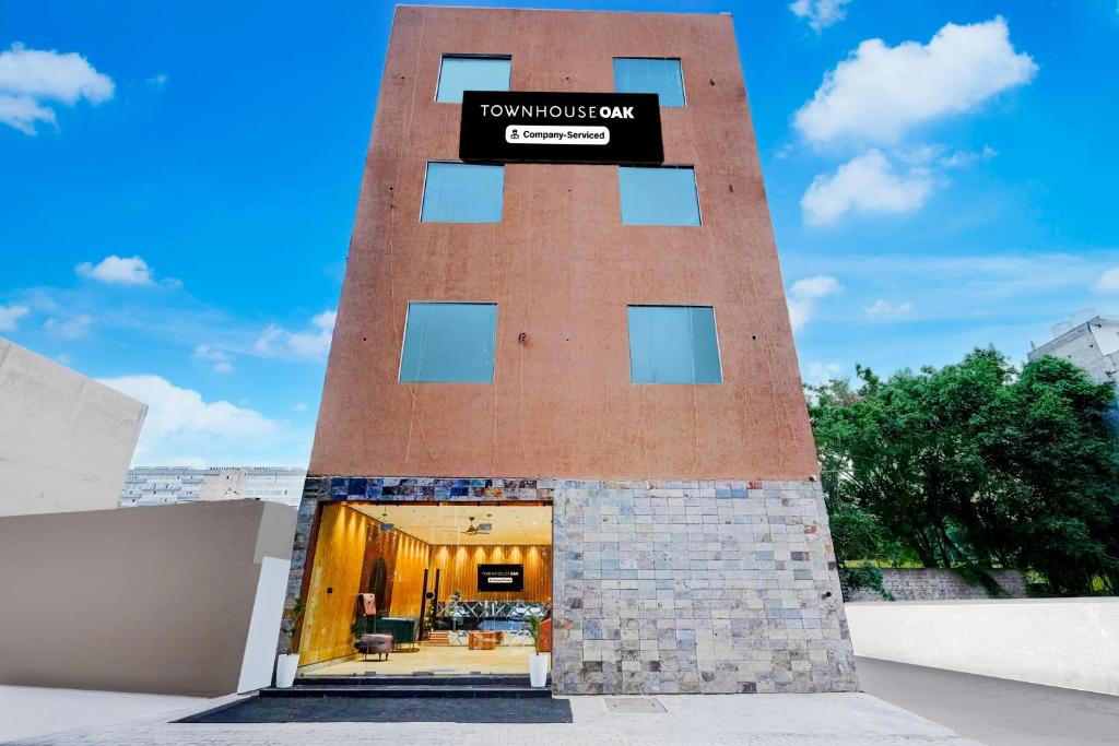 a tall brick tower with a sign on it at Super Townhouse OAK Chandigarh Ambala Expressway Gazipur Formerly Troy Resorts and Wellness in Zirakpur
