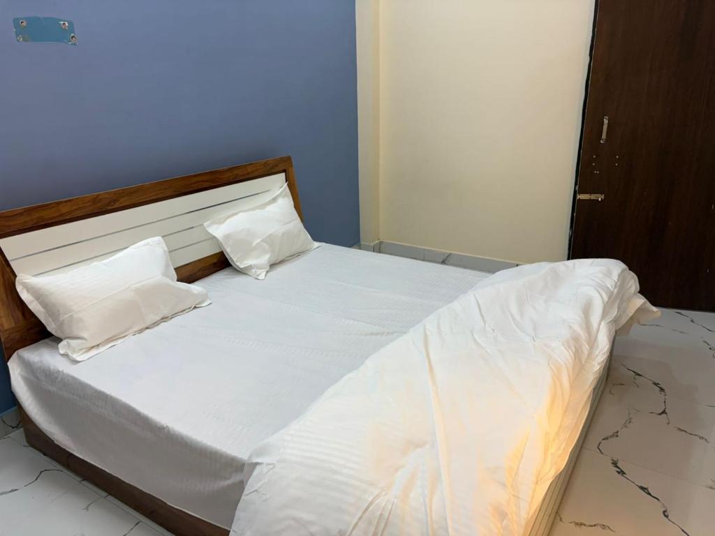 a bed with white sheets and pillows on it at Divine House in Lucknow
