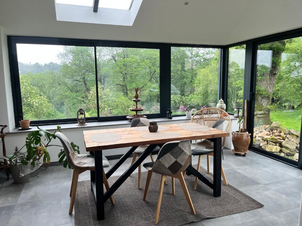 a dining room with a table and chairs and windows at At Home in Cruguel