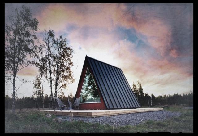 a small house with a triangular roof in a field at Glamping hut with panorama view in Björköby