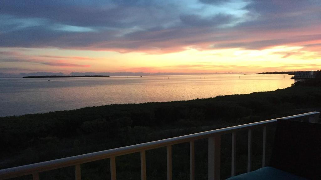 a view of the water at sunset from a balcony at 4409 Ocean Pointe Suites in Tavernier