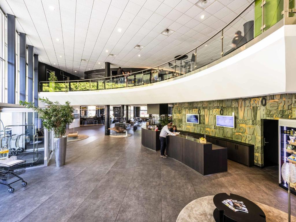 Eine Frau steht in der Lobby eines Gebäudes in der Unterkunft Novotel Bern Expo in Bern