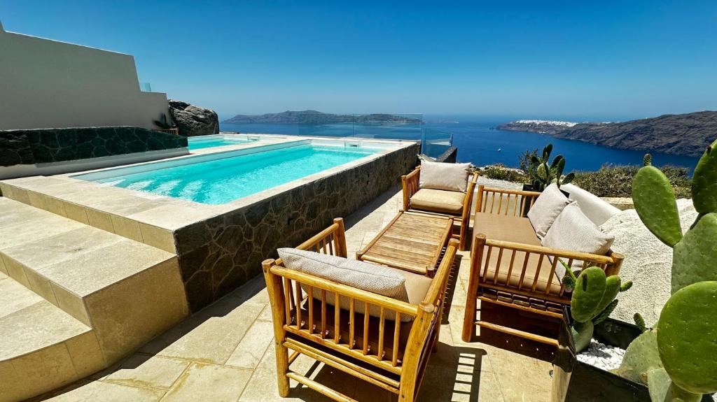 a group of chairs sitting next to a swimming pool at Caldera Serenity - Small Luxury Villas in Imerovigli