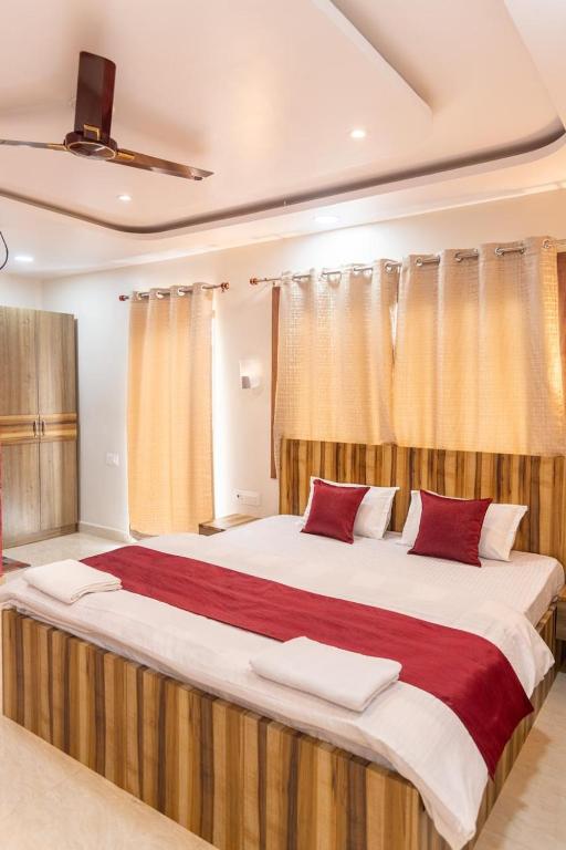 a bedroom with a large bed with red and white pillows at Raghuvansh Hotel in Gaya