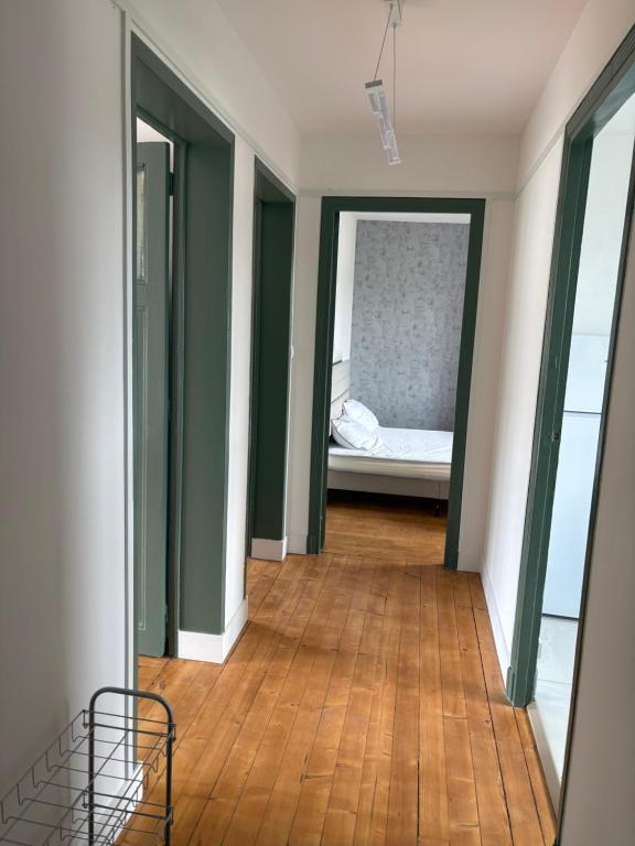 a hallway with a bed in a room with green walls at Gambetta in Rethel