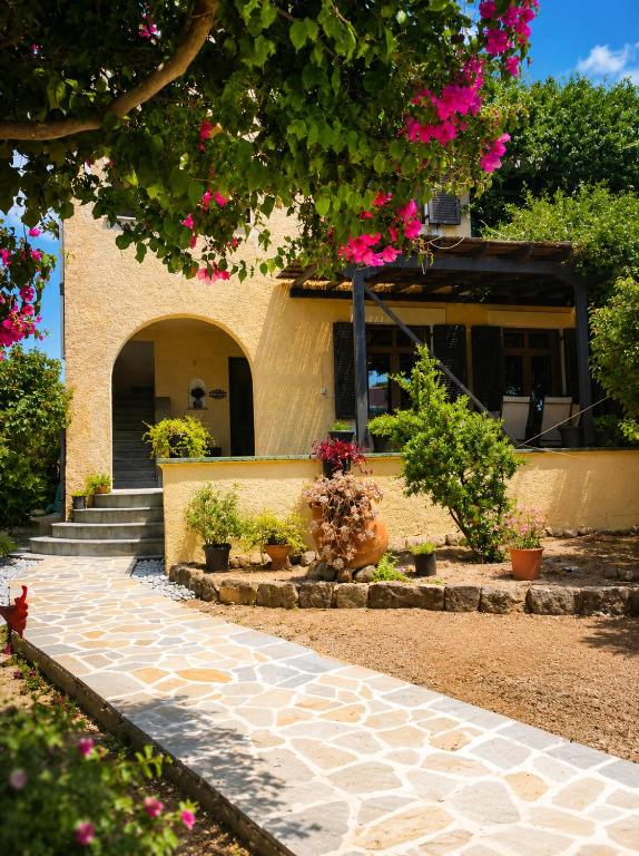 a house with flowers on the side of it at Billy's Place in Egina