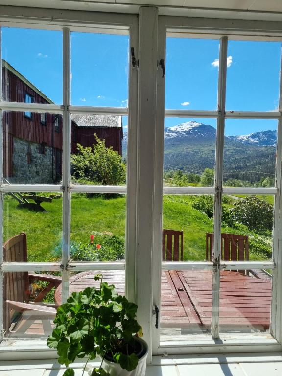 an open window with a view of the mountains at Staurset gård in Mittet