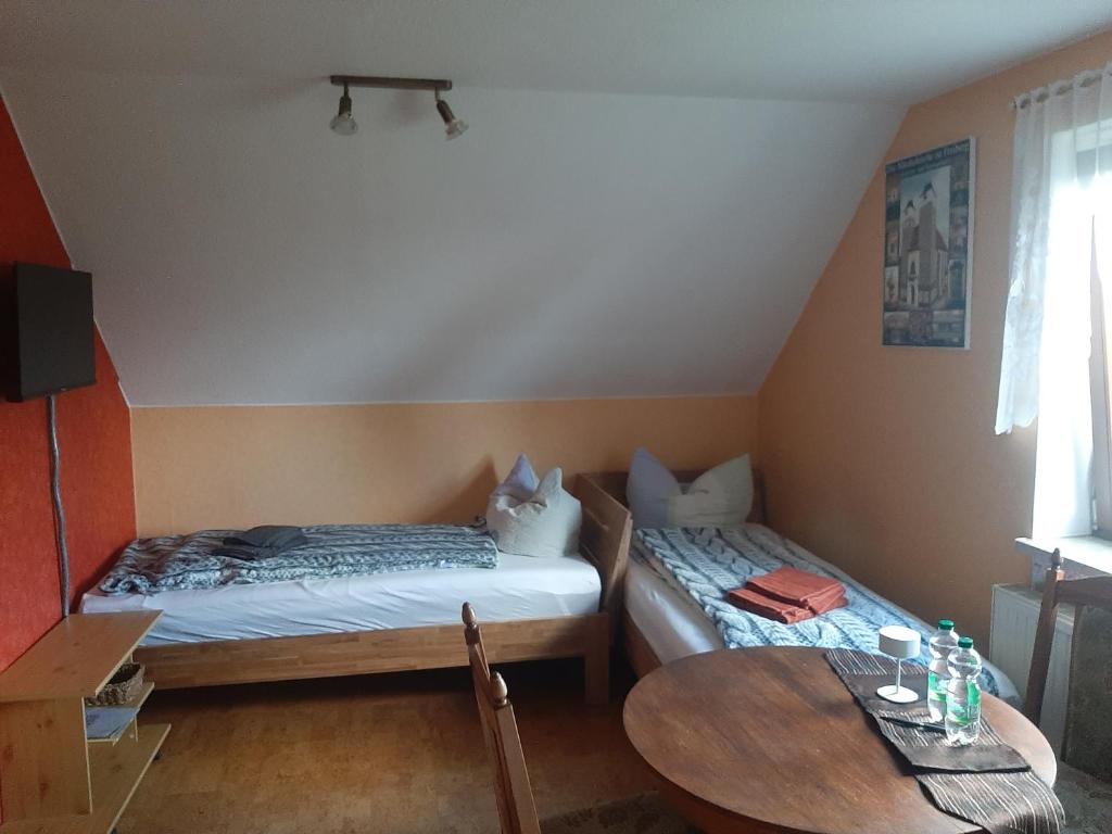a room with two beds and a table in it at Kleines Idyll in Bieberstein