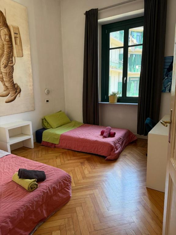 a room with two beds and a window at Centro - doppia in casa d'artista in Turin