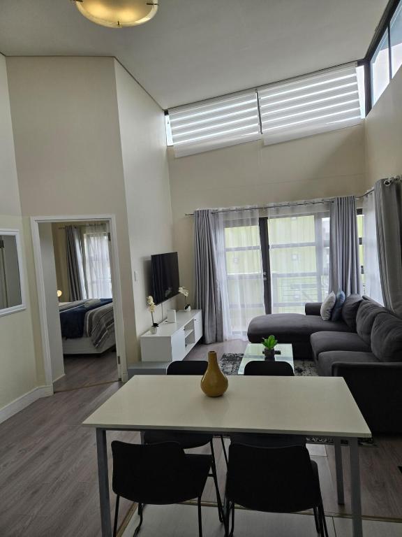a living room with a couch and a table at Beautiful 2 bedroom unit, inverter & complex pool in Johannesburg