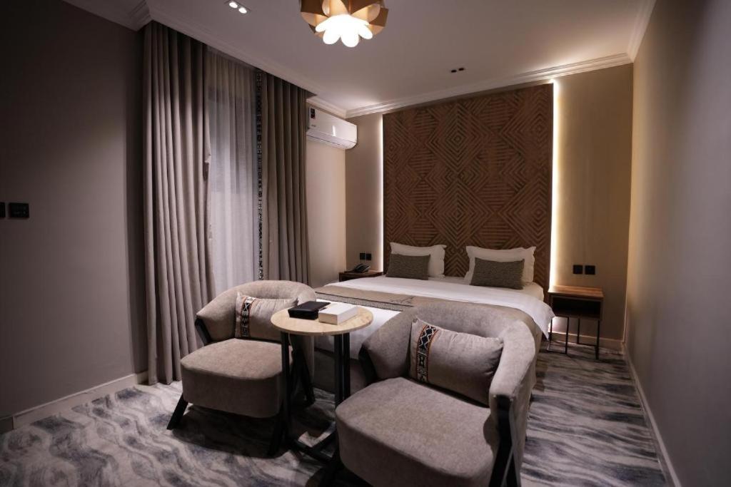a hotel room with a bed and two chairs at فندق اناف in Medina