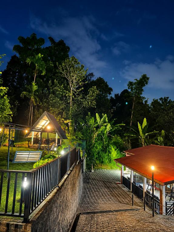 a resort with a fence and a table and a building at Beloved Regency Homestay in Kandy