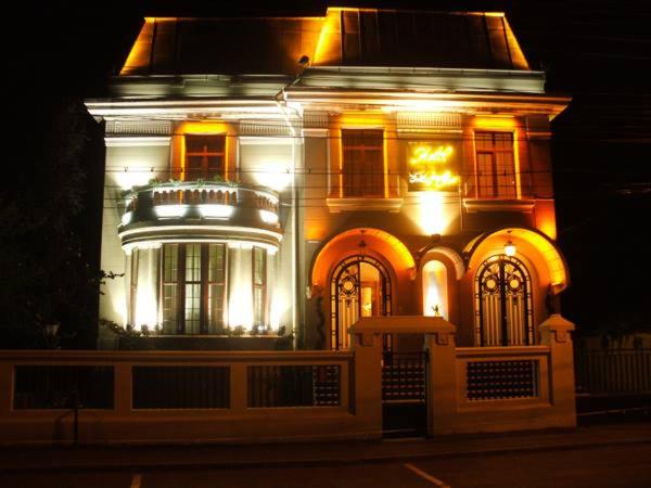 a lit up building with lights on it at night at Angelo Doro Hotel in Ploieşti
