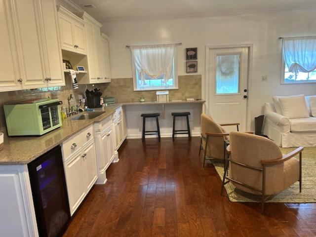 a kitchen with white cabinets and a table and chairs at Cozy Luxury Cottage in Alachua